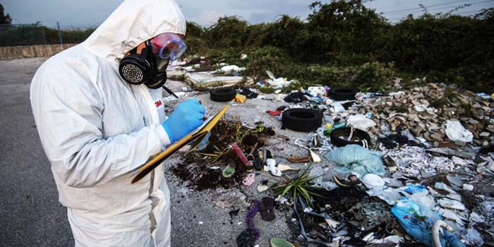 Operatore con dispositivi di sicurezza in mezzo a una zona altamente inquinata